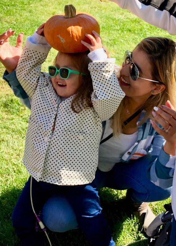 Child with pumpkin balanced on her head